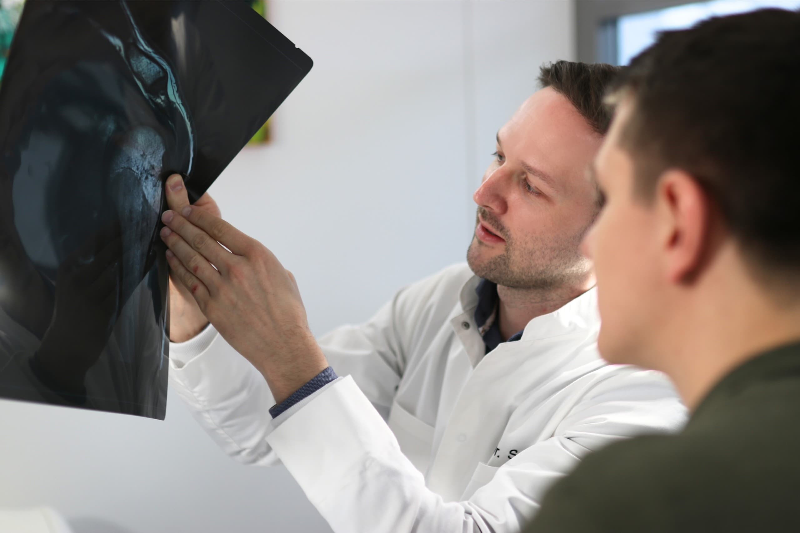 Dr. Schett analysiert Röntgenaufnahme mit Patient – präzise Diagnostik